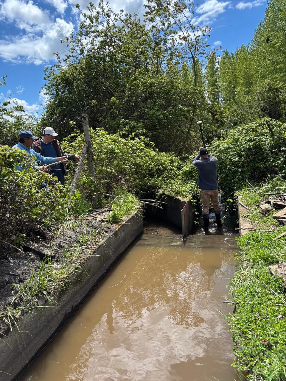 Medición de un canal de riego durante una visita técnica